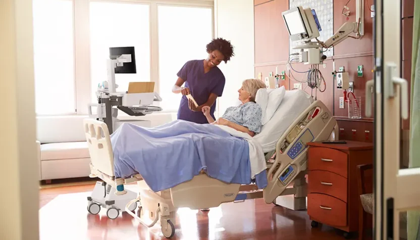 Doctor talking to patient on hospital bed.